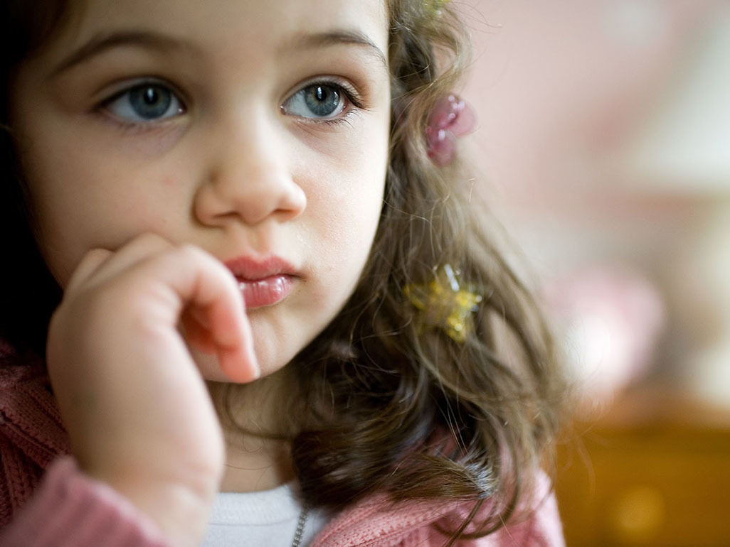 little girl with blue eyes and star hairclips in her brown hair