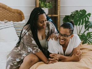 A couple embracing and smiling on a bed