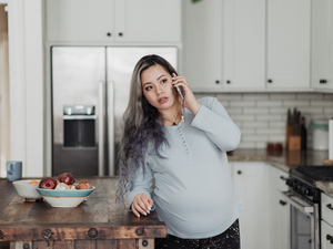 pregnant woman on phone looking concerned