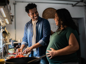 pregnant couple cooking in the kitchen