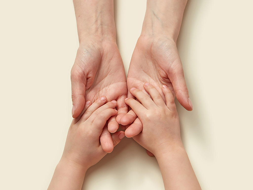 adult hands holding child's hands